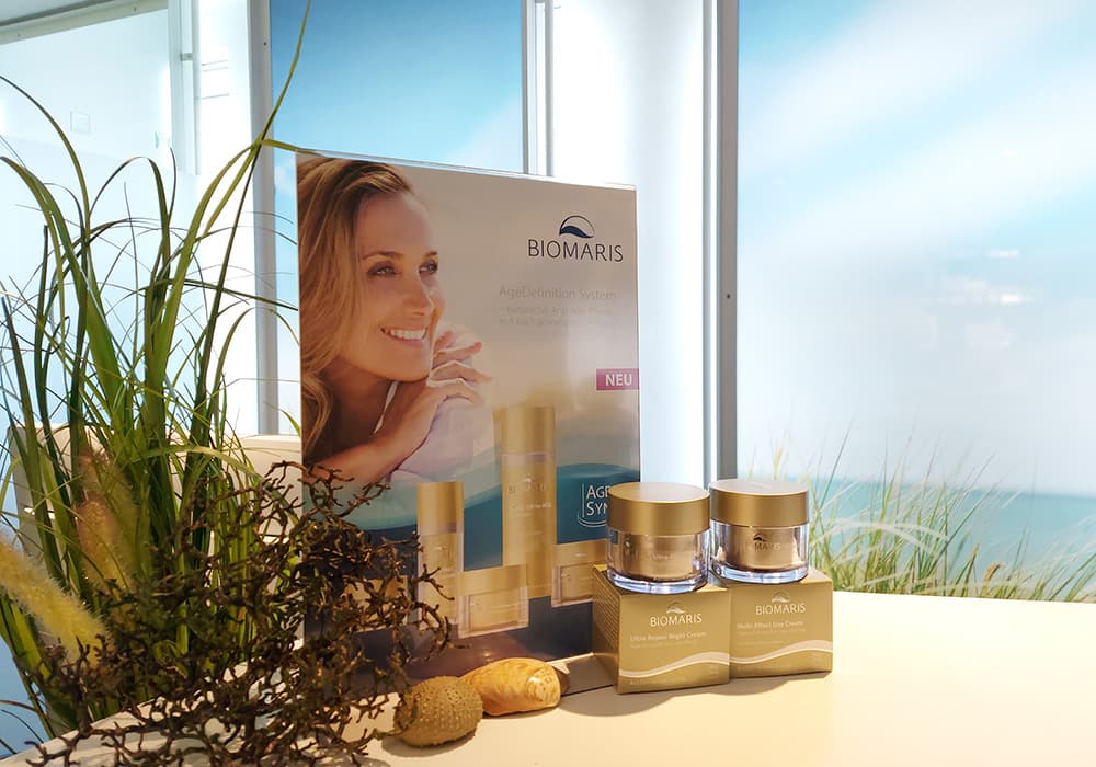 BIOMARIS Kosmetik-Institut Verkauf Empfangstresen mit Produktaufsteller, BIOMARIS Anti-Age-Pflege und zwei Cremedosen vor maritimem Dekor