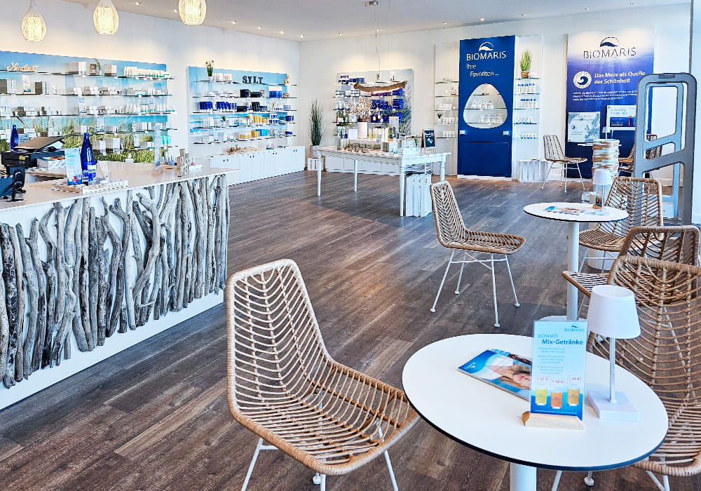 Innenansicht des Biomaris Shops. Zeigt die Kasse, Sitzgelegenheiten und Warenregale.