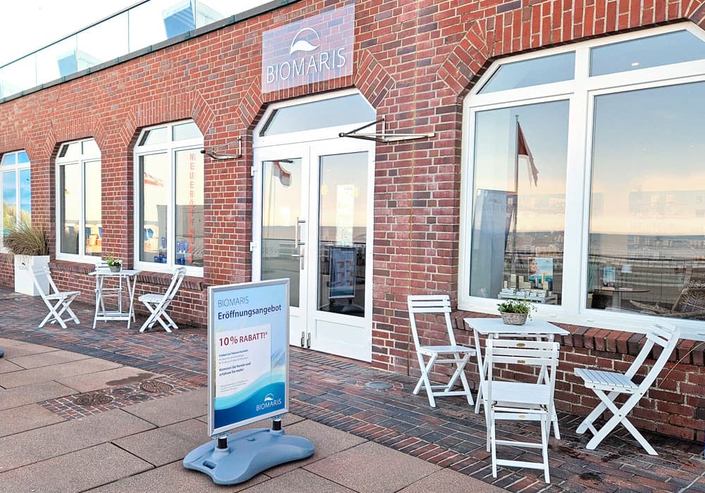 Außenansicht des Biomaris Shops Westerland mit Sitzgelegenheit vor dem Eingang, der gut sichtbar ist.
