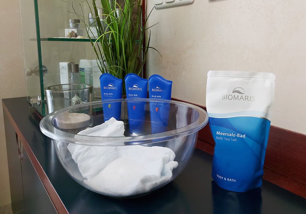 BIOMARIS Kosmetik-Institut Kabine BIOMARIS Kosmetik-Institut mit AromaThalasso Produkten und Meersalz-Bad auf schwarzem Tisch