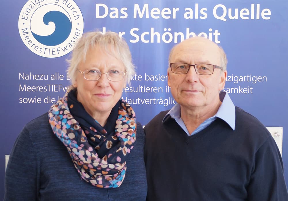 BIOMARIS Shop Büsum - Shop-Betreiber Betreiber-Ehepaar des BIOMARIS-Shops in Büsum vor blauem Hintergrund mit Infotext