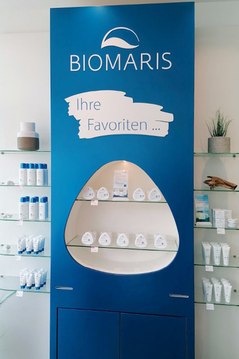 Präsentationswand mit Schriftzug „Ihre Favoriten“ und weißen Cremedosen im BIOMARIS-Shop