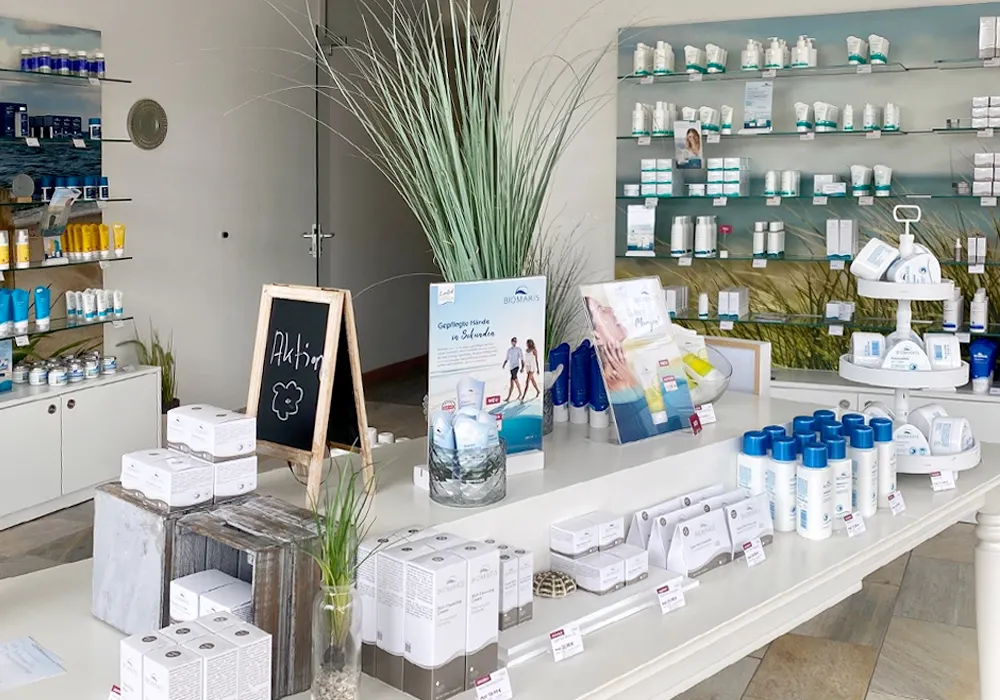 Präsentationstisch mit Pflegeprodukten und Aufstellern, im Hintergrund Regale mit weiteren Produkten im BIOMARIS Shop