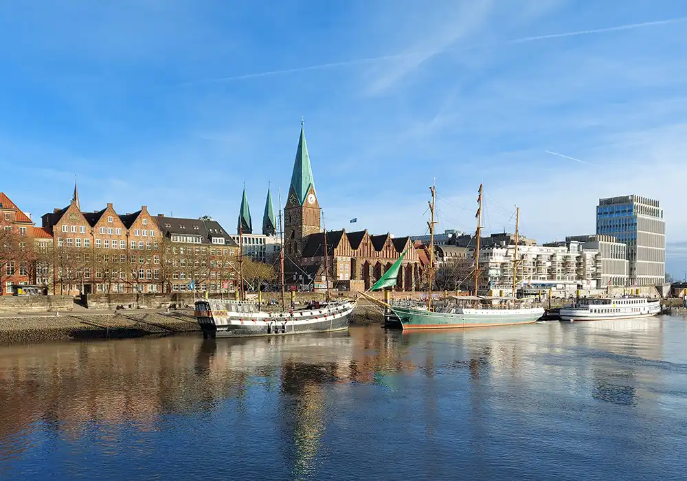 Blick über die Weser in Bremen mit historischen Gebäuden, Dom und Segelschiffen